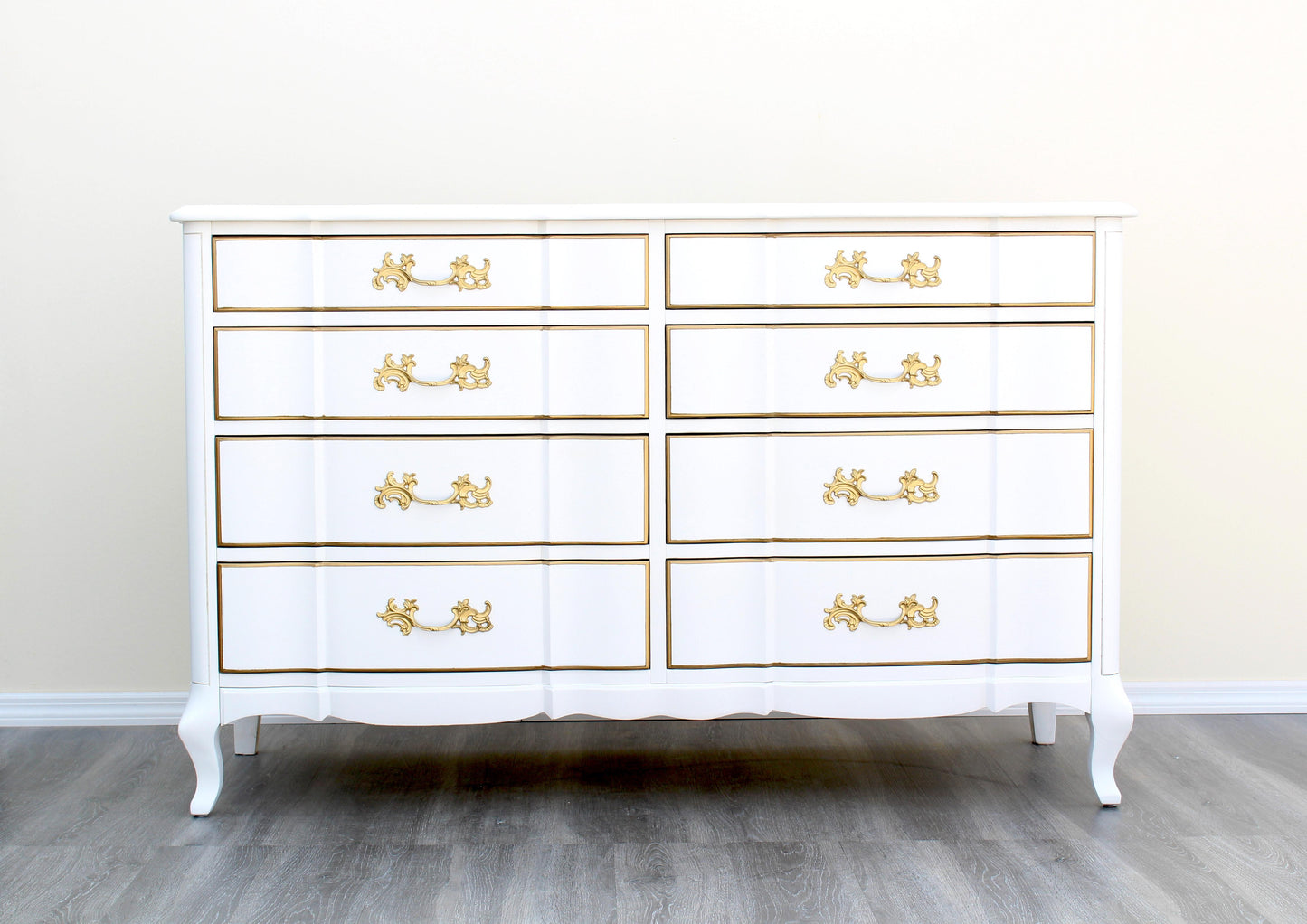 1970's French Provincial Dresser of Eight Drawers by Permacraft.  This dresser is solid built with dovetail joints and metal hardware, is newly refinished in white and gold with a satin topcoat.  Dimensions: 54"Width x 20"Depth x 34"Height. 