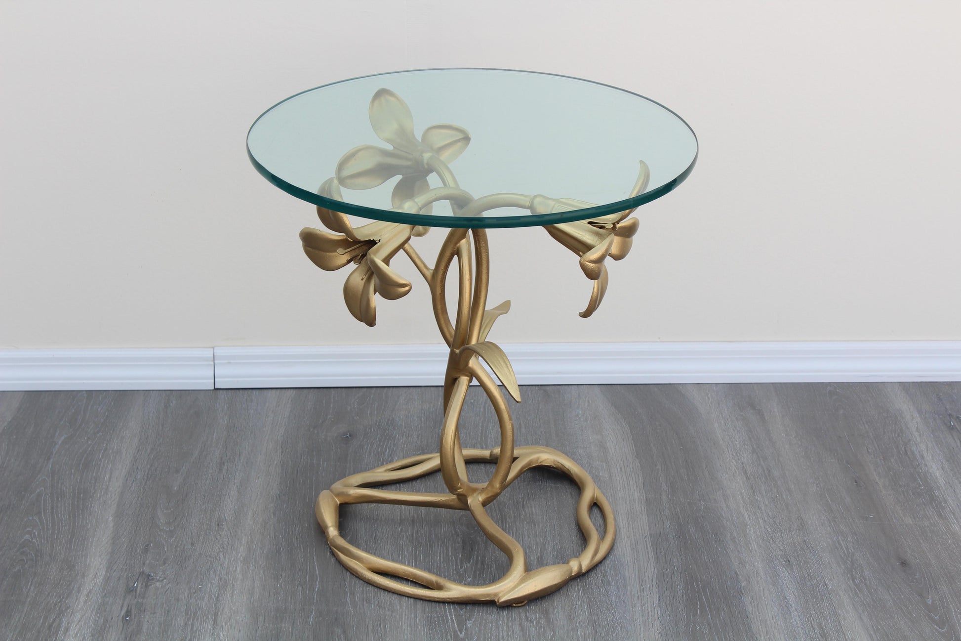 1970's Gold Painted Lily Flower Metal Side Table with Glass Top.  This table has minor wear and overall, in great condition.  Dimensions: 20"Width x 20"Depth x 20"Height. 