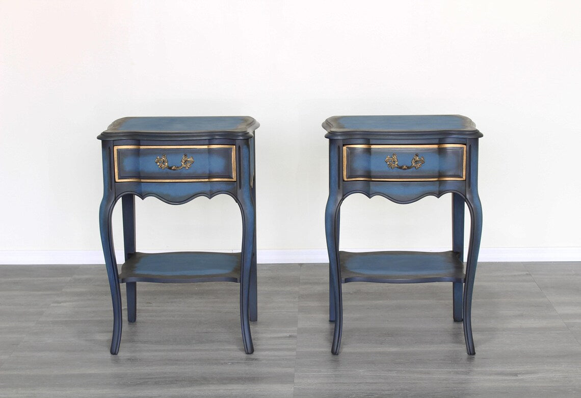 Vintage solid built French style nightstands with dovetail joints.  The nightstands are professionally refinished in blue with an antique glaze and gold painted accents.  Dimensions; 19" Width x 15" Depth x 29"Height. 