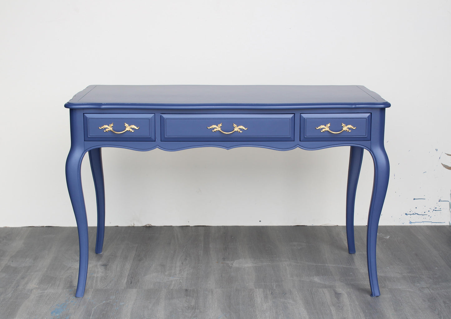 Vintage French Provincial desk of three drawers.  This desk is solid built with dovetail joints is professionally refinish in blue with satin top coat, and gold painted hardware.  Dimensions: 48"Width x 25"Depth x 30"Height.