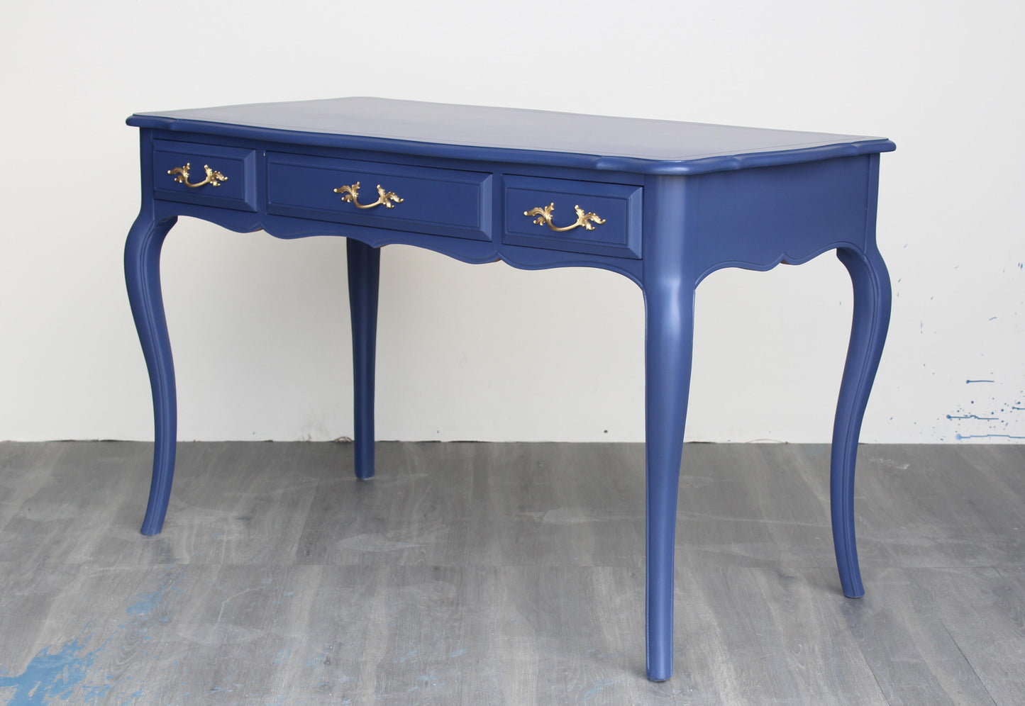 Vintage French Provincial desk of three drawers.  This desk is solid built with dovetail joints is professionally refinish in blue with satin top coat, and gold painted hardware.  Dimensions: 48"Width x 25"Depth x 30"Height.