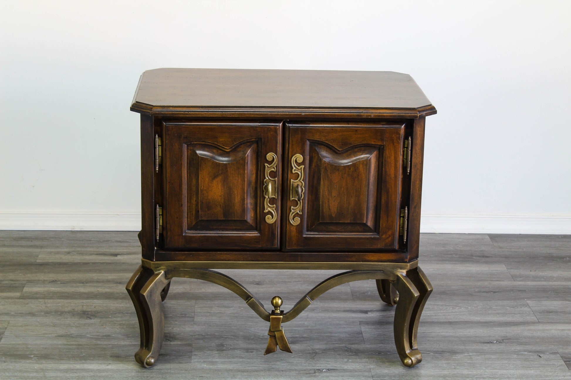 Vintage solid built double door nightstand with an interior single bin.  The nightstand is mounted on metal legs and has the original brass hardware.  Dimensions; 27.5" Width x 19" Depth x 25" Height. 