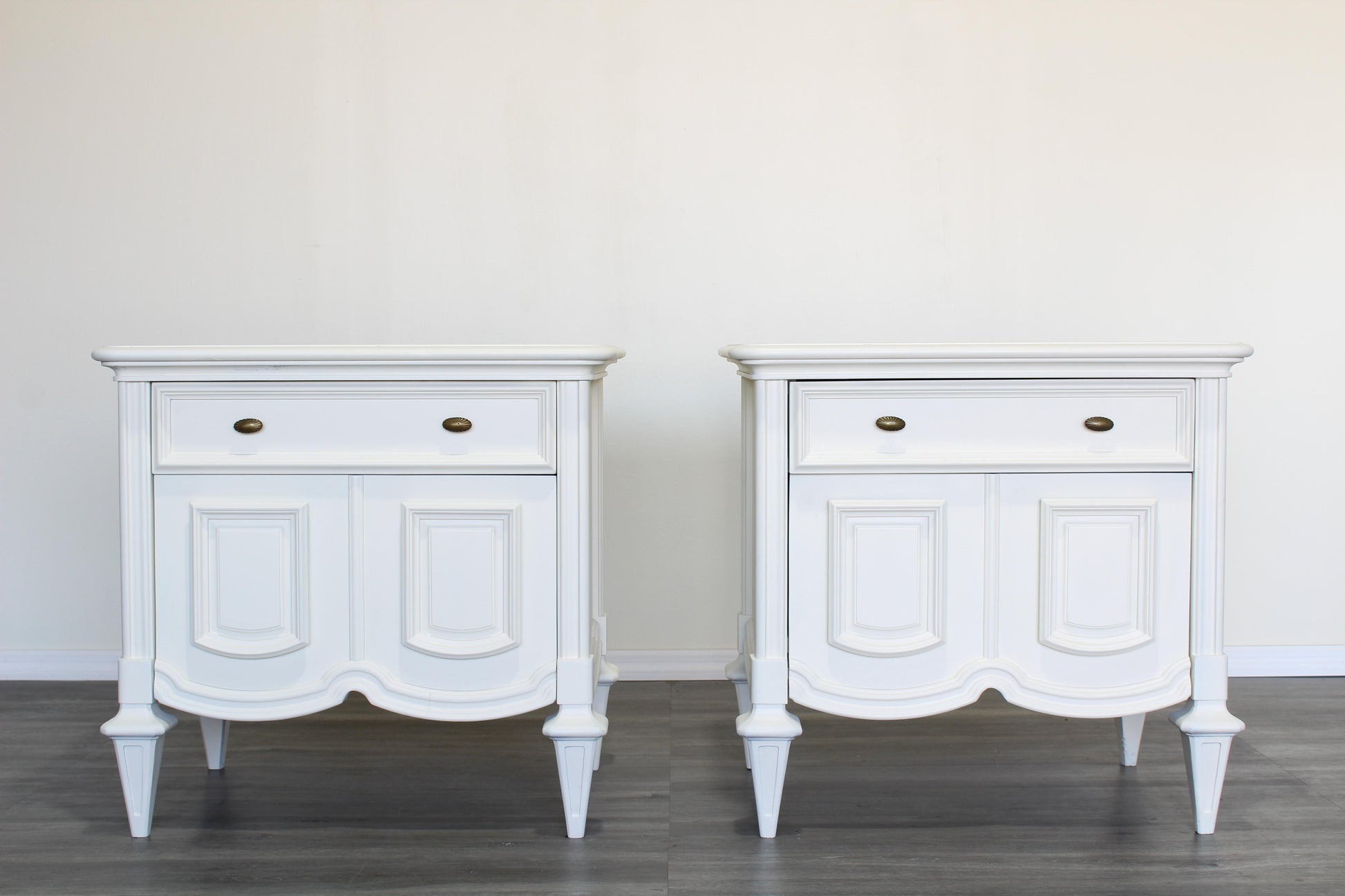 Pair of Mid century modern cream nightstands.  The nightstands are solid built with dovetail joints, are professionally refinished in a white cream color with a satin finish.  Dimensions; 27" Width x 19" Depth x 26" Height.