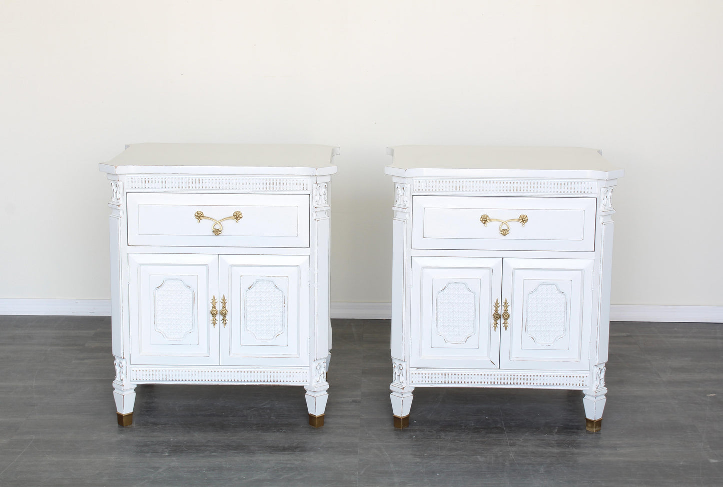 Pair of white neoclassical style nightstands.  The nightstand are solid built with dovetail joints, are professionally refinished in white with a distressed finish.  Dimensions: 25"Width x 20"Depth x 28"Height. 