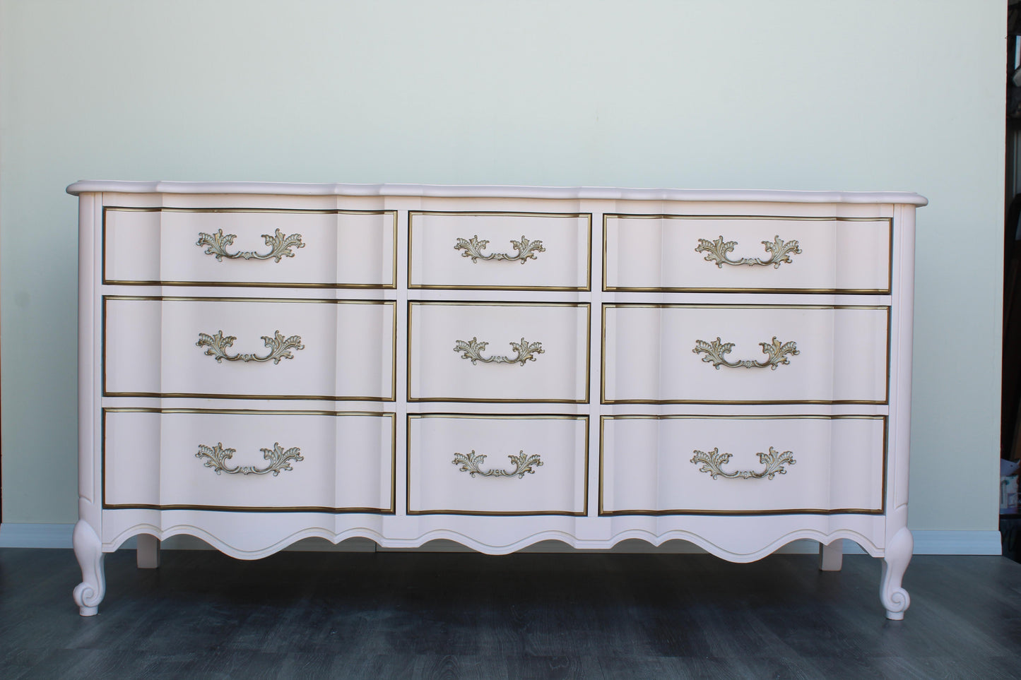 Vintage French provincial solid built dresser of nine drawers.  This dresser was professionally refinished in a Champagne pink and gold with satin top coat.  Dimensions: 64"Width x 20"Depth x 32"Height. 