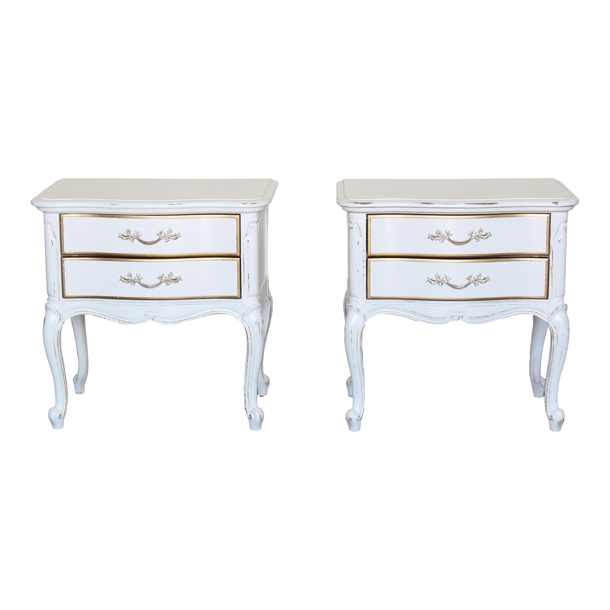 Vintage pair of French provincial nightstands of two drawers.  The nightstands are solid built with dovetail joints, are professionally refinished in white with a distressed finish and gold painted accents.  Dimensions: 24.5"Width x 16"Depth x 24"Height.