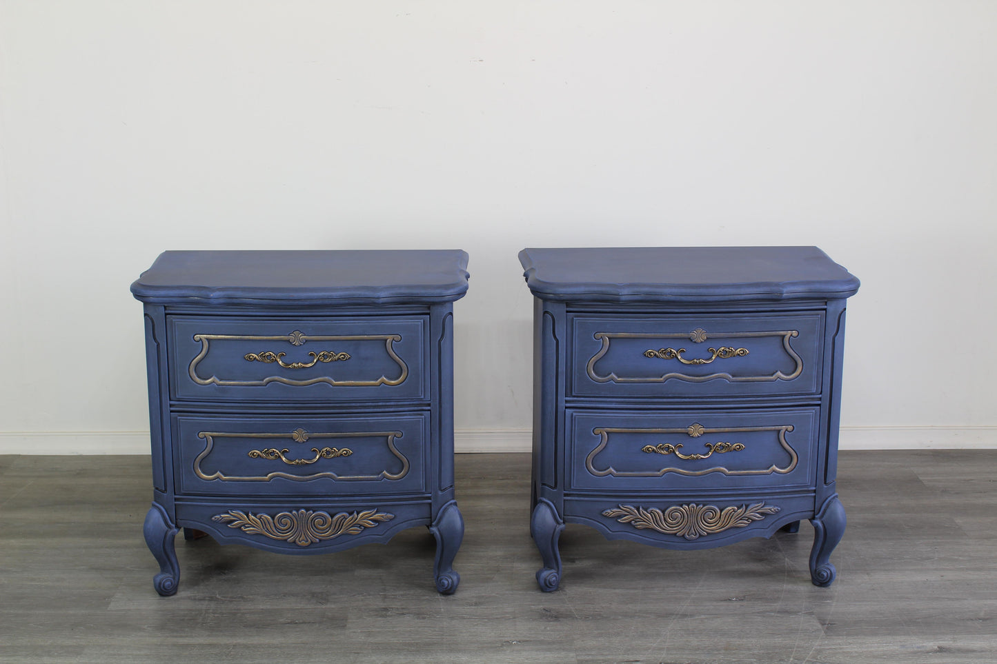 Vintage pair of French style nightstands of two drawers.  The nightstand are professionally refinished in blue with gold painted accents in an antique glaze.  Dimensions; 26" With x 15" Depth x 25" Height. 