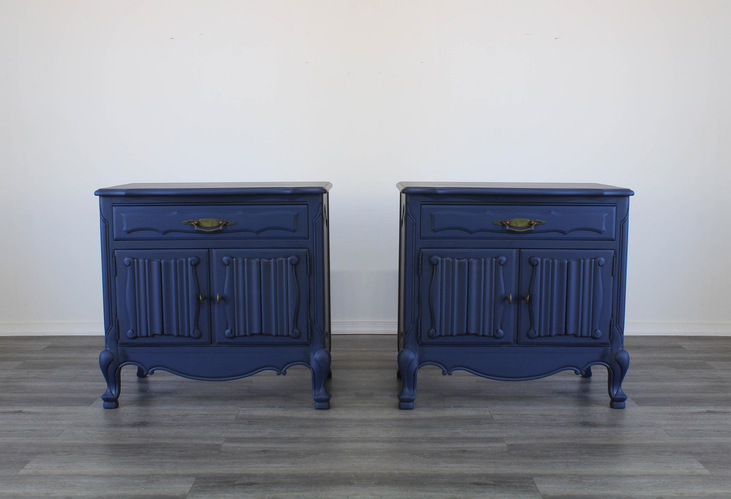 Vintage pair of French Style Nightstands.  These nightstands are solid built with a dovetail drawer and double doors that open to a storage space.  These nightstands are professionally refinished in blue with antique glaze and brass hardware.  Dimensions; 27" Width x 17" Depth x 27" Height. 