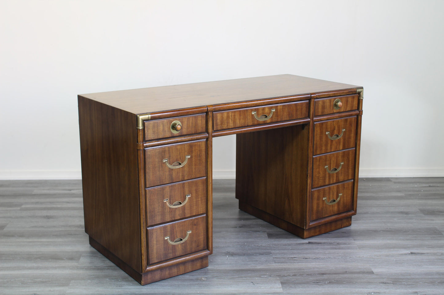 Mid century campaign style desk of nine drawers with metal hardware.  Minor wear, in great vintage condition.  Dimensions; 51" Width x 24" Depth x 30" Height. 