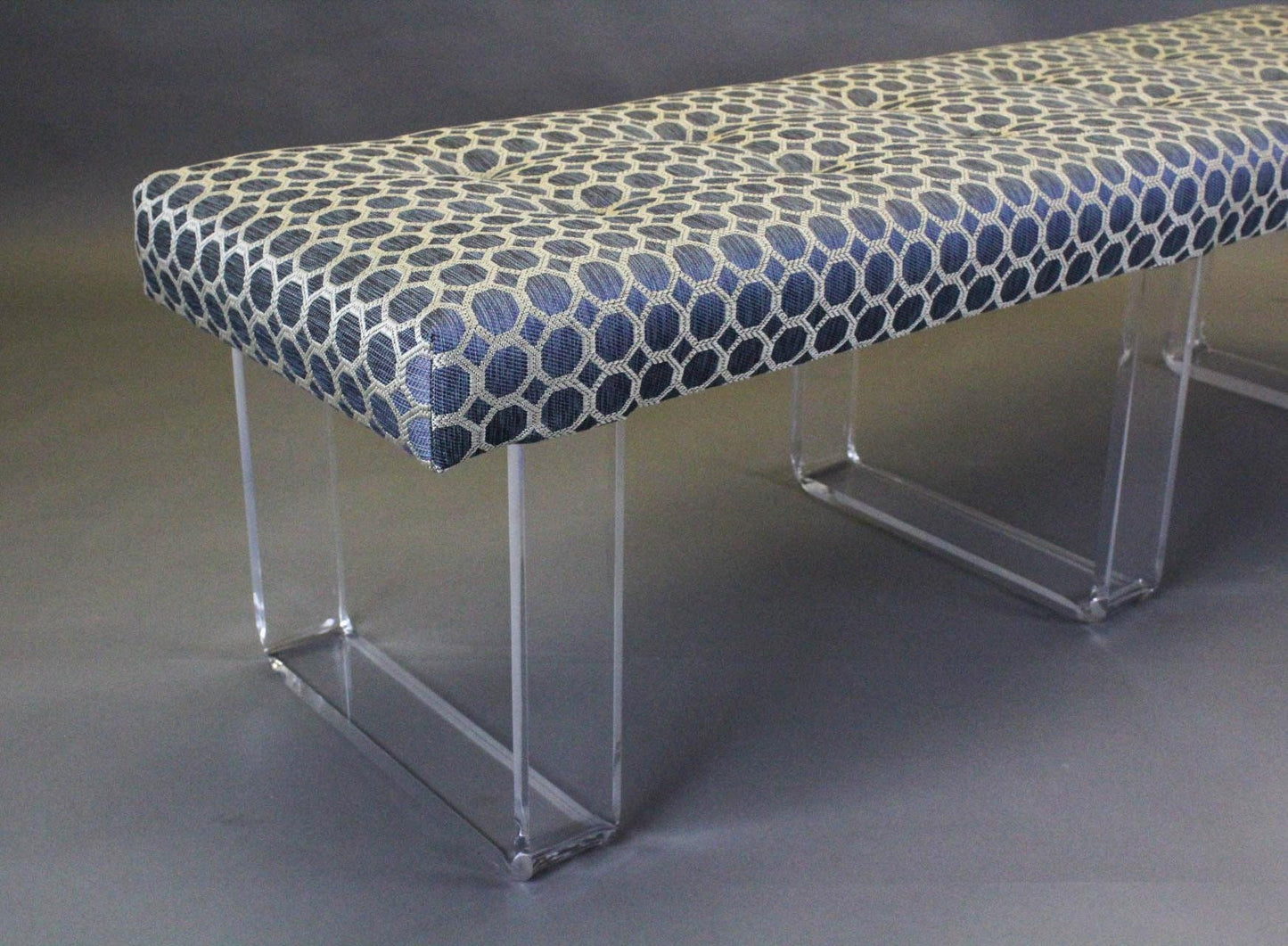 Exclusive infinity style Lucite Bench This bench was upholstered in a luxurious blue brocade chenille and is supported by the infinity acrylic legs creating the illusion of a floating cushion This is a limited edition. Benches are in excellent condition Dimensions: 56"Width x 16"Depth x 17"Height.