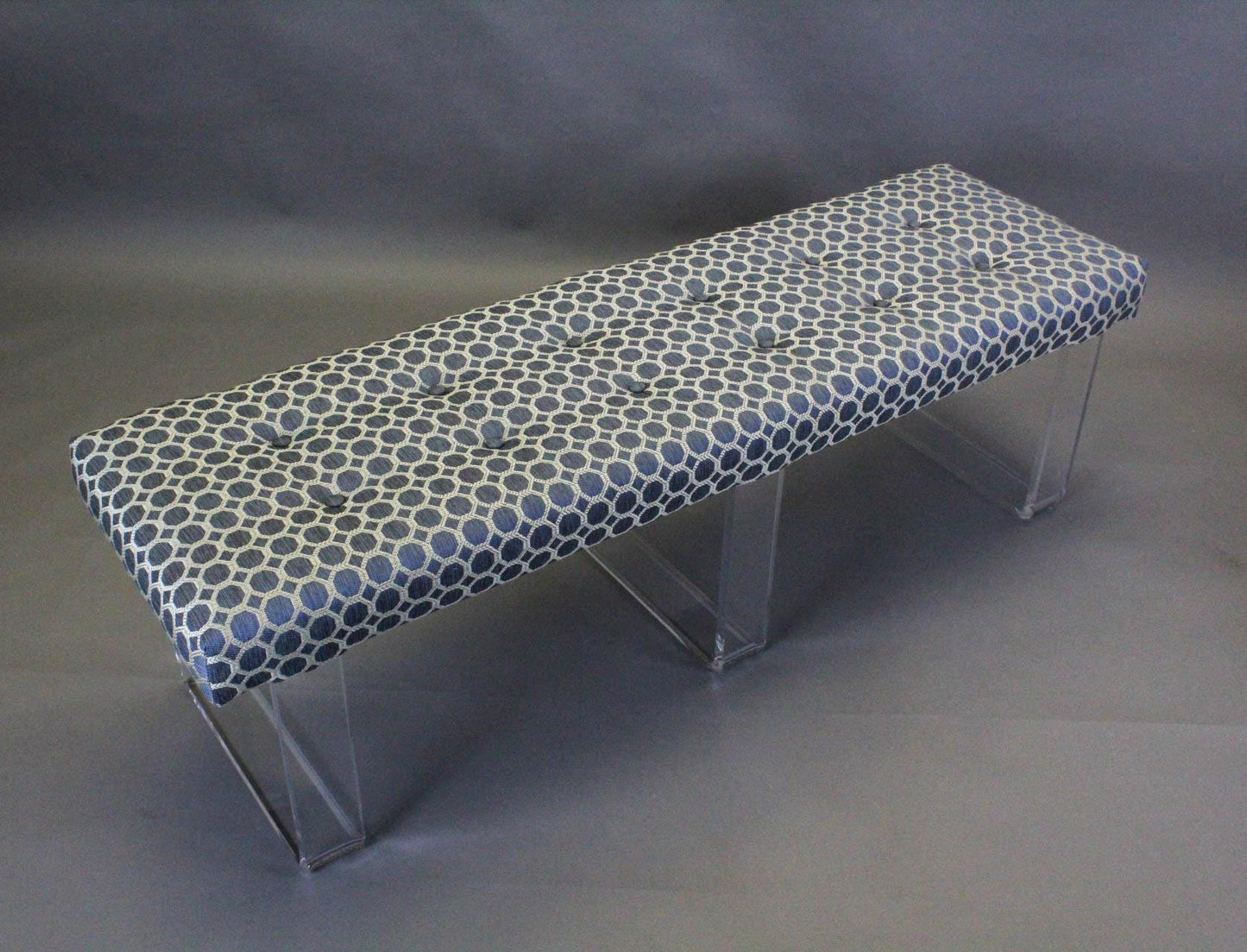 Exclusive infinity style Lucite Bench This bench was upholstered in a luxurious blue brocade chenille and is supported by the infinity acrylic legs creating the illusion of a floating cushion This is a limited edition. Benches are in excellent condition Dimensions: 56"Width x 16"Depth x 17"Height.