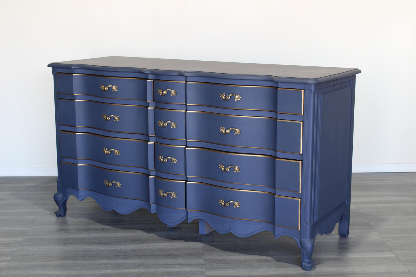 Vintage French provincial blue dresser of twelve drawers.  This dresser is solid built with dovetail joints.  This dresser is painted in blue with antique glaze and gold painted accents.  Dimensions; 62" Width x 22" Depth x 34" Height. 