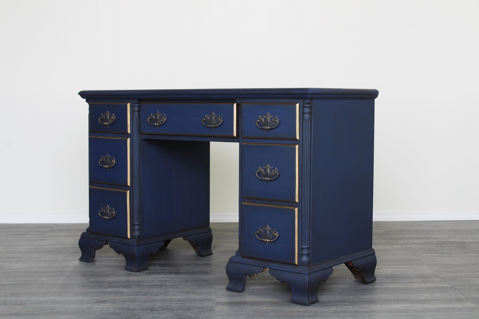 Vintage solid built desk of seven drawers with dovetail joints.  This desk is professionally refinished in blue with antique glaze and dry brushed finish with gold painted accents.   Dimensions; 45" Width x 20" Depth x 31" Height.